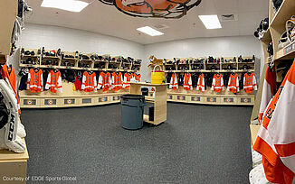 Thayer Sports Center Locker Room with REGUPOL aktiv Flooring An empty locker room with REGUPOL aktiv Rolled Rubber Flooring and rows of lockers, filled with gear.