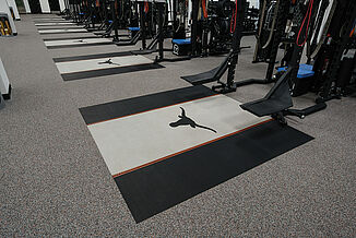 University of Texas at Austin Weight Training - Rows of Platforms Angled view of rows of weight racks found at the University of Texas at Austin. Individual platforms are offered for each weight rack, featuring REGUPOL crash and aktivpro roll, with a customized team logo.