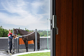 REGUPOL Equestrian Flooring for Outdoor Wash Bays – Slip-Resistant and Weather-Resistant Flooring Solutions Outdoor horse wash bay with slip-resistant REGUPOL equestrian flooring – weather-resistant, shock-absorbing flooring for safe grooming and washing areas at equestrian facilities