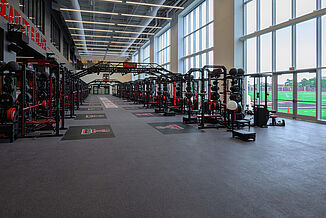 Texas Tech Football - Far View to Entrance View of entrance of Texas Tech Football weight room, showcasing the number of weight training racks and REGUPOL crash platforms.