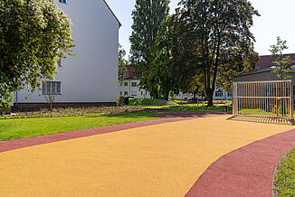 Accessible play and recreation area in Berlin-Steglitz-Zehlendorf featuring REGUPOL playfix fun impact-absorbing safety surfacing and REGUPOL multicourt DLX sports surfacing.