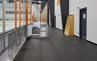 Thayer Sports Center Walkway at Ice Rink Walkway around the ice rink in the Thayer Sports Center. The walkway features REGUPOL aktiv rolled rubber flooring. Doorways throughout the walkway lead to locker rooms and offices throughout the facility.