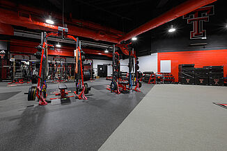 Texas Tech Volleyball - Turf and Rubber Transition View of the transition between REGUPOL aktivpro roll flooring and the turf area in the Texas Tech Volleyball weight room. The combination of flooring allows for increased training capabilities.