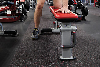 UFC Gym - Weight Bench and REGUPOL aktiv Flooring A weight bench rests atop REGUPOL aktiv rolled rubber flooring in the UFC Gym in Lancaster. The athlete utilizes the bench to perform weighted dumbbell rows.