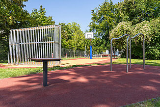 Inclusive sports and play area in Berlin-Steglitz-Zehlendorf with REGUPOL impact-absorbing safety surfacing, sports surfacing, a basketball court, and calisthenics equipment.
