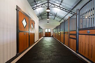 REGUPOL Verbundpflastersteine aus schwarzem Gummi Blick in den Pferdestall mit Stallgasse aus Verbundpflaster