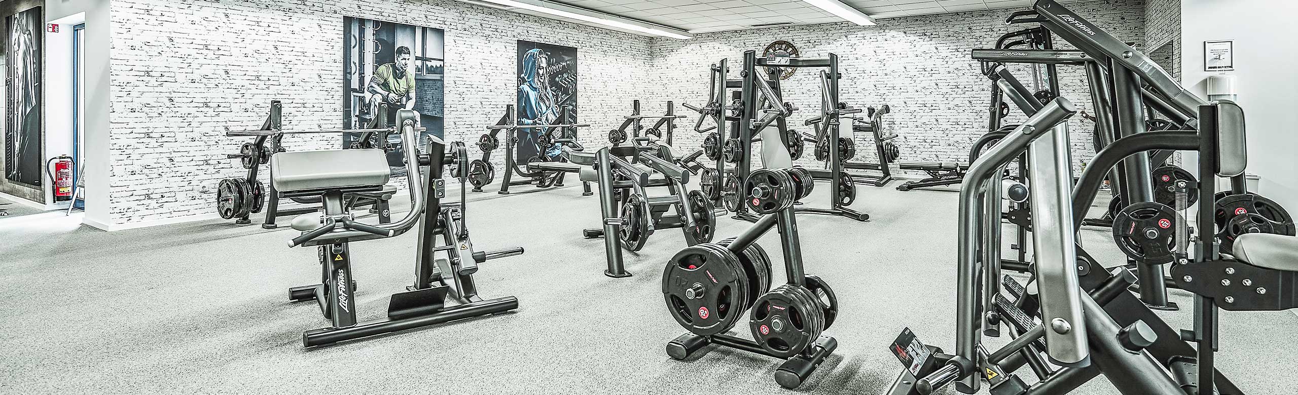 Various fitness machines for machine training in a room. Various fitness machines for equipment training in one room. The room is bright, the walls are white and the REGUPOL flooring is light gray.