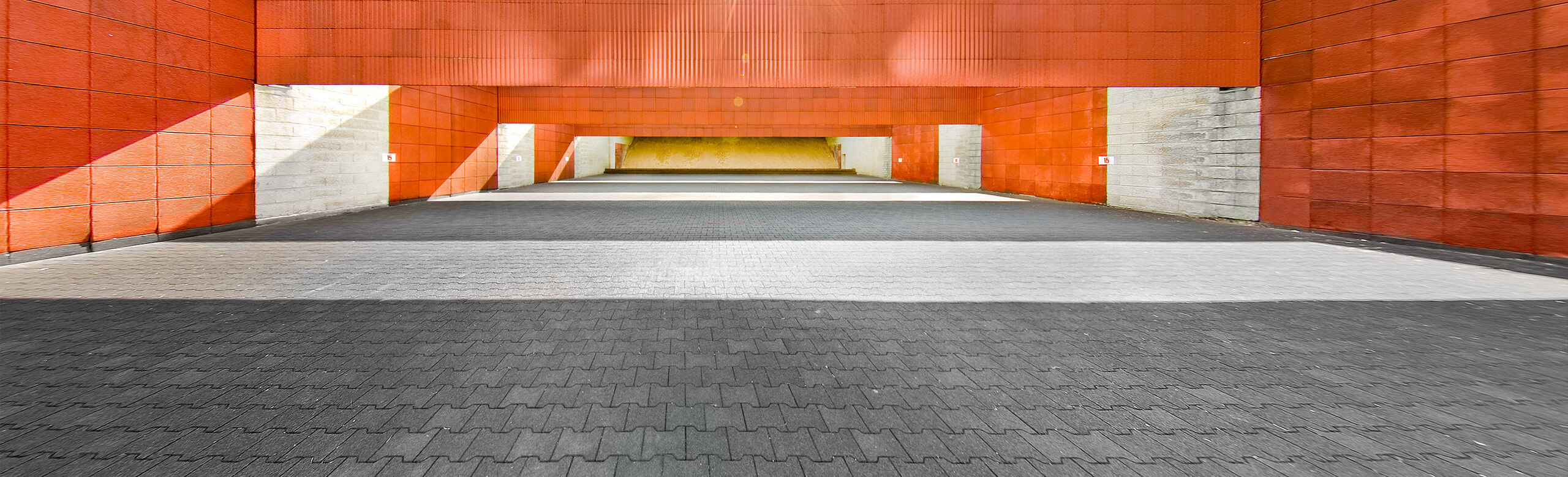 An outdoor shooting range with a grey interlocking pavers as floor
