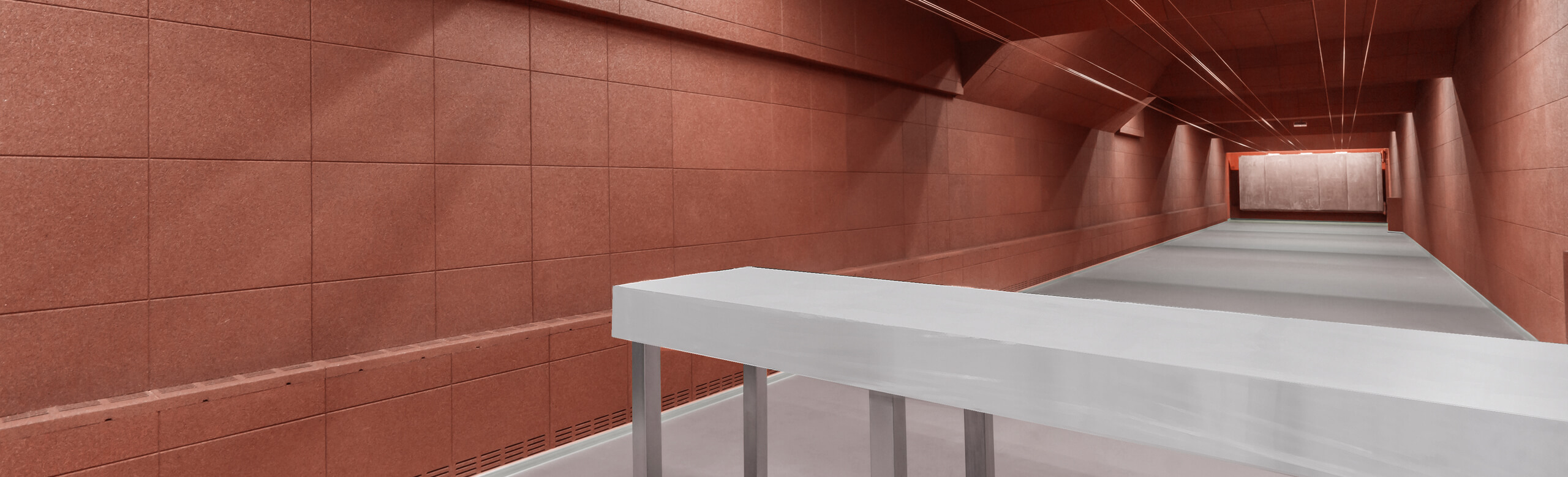 Wall with red elasticated panels in shooting range A wall in a shooting range is fitted with red REGUPOL elastic panels.
