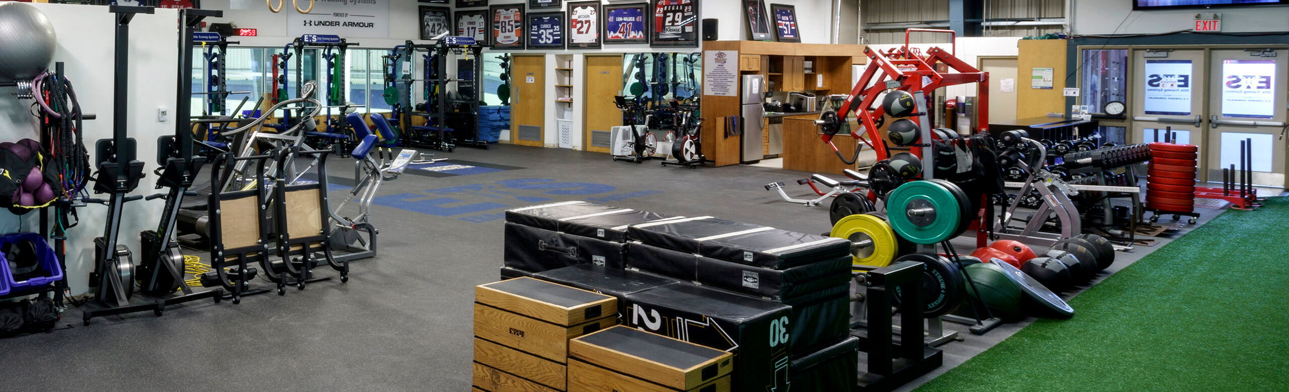 Elite Training Systems at Iroquois Park Sports Centre - Training Facility View of the Elite Training Systems facility at the Iroquois Park Sports Centre. The training center features a variety of equipment and machines for athletes, as well as a turf area and REGUPO aktivpro roll flooring throughout.